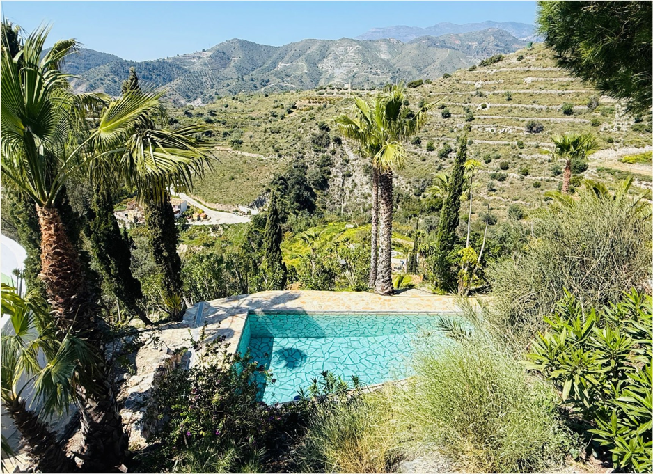 Gardens and pool at Finca Indigo with the Costa Tropical hills beyond